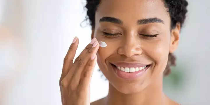 Aplicación de crema facial como parte de una rutina diaria de cosmética ecológica